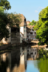 Obraz premium Half-timbered houses at a water canal in the picturesque old town (La Petite Fance) of Strasbourg during a summer day (Strasbourg, France, Europe)