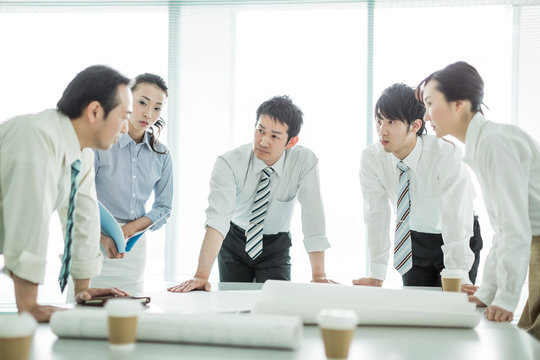 打ち合わせで真剣に話しを聞くビジネスマンとビジネスウーマン