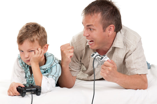 Father and Son Playing Video Games --- Image by © Royalty-…