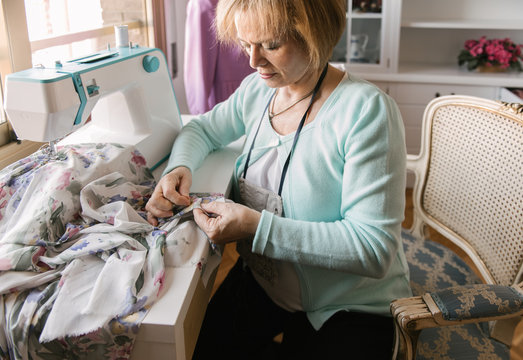Senior woman using sewing machine