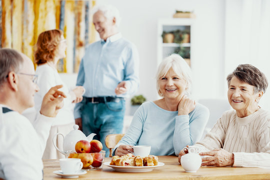 Happy senior people enjoying their meeting, talking and sharing memories while drinking tea at nursing home