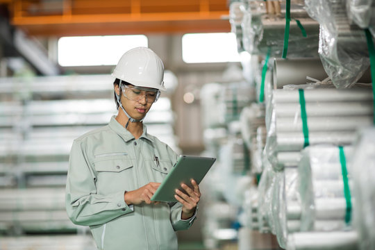 タブレットPCを操作する作業服の男性