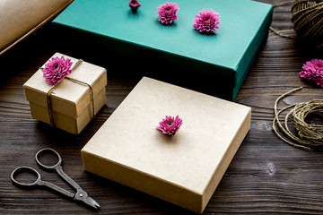 wrapping gifts in box for holiday on wooden background