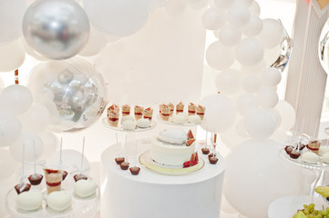 Candy bar decoration setup with delicious cakes and sweets.