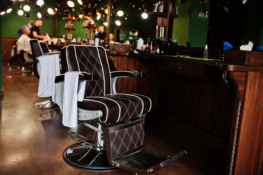 Brown vintage leather chairs at stylish barber shop.