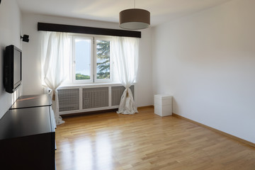 Empty room with window, curtain and parquet