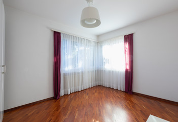 Empty room with window, curtain and parquet