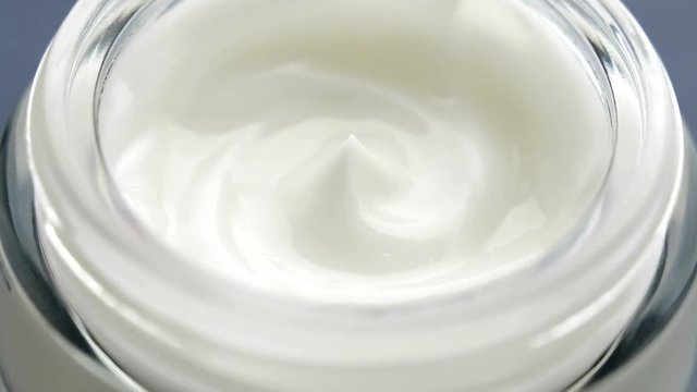 Cosmetics cream with rotate. Cream white background texture. Close-up shot.