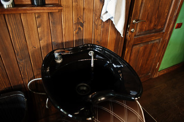 Black washbasin or sink at barber shop.