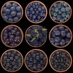 set of black and blue berries isolated on black background