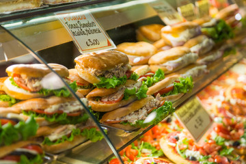 Varied sandwiches and pizza on the counter of a street cafe