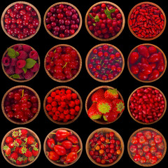 set of red berries in wooden cups in black background isolated