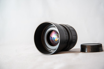 Photo lens from a SLR camera with beautiful colored glare on lenses on a bright background