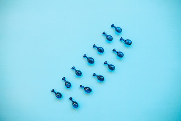 Fillers or capsules with hyaluronic acid on a blue background. Skin care and facial health.