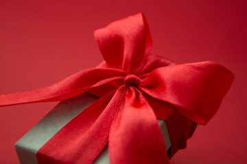 Close up gift box, birtday gift with red bow on red background. Love, Valentine's Day, Mother's Day.