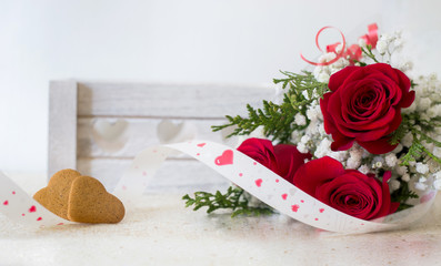 red roses bouquet with heart shaped cookies background