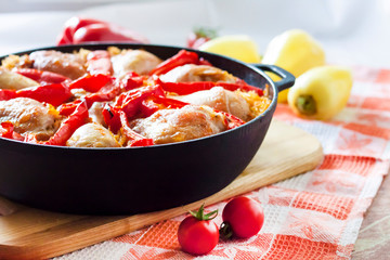 Chicken thighs and legs baked over a bed of rice and red bell pepper