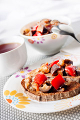 Vegetable stew with eggplant, red pepper and tomatoes on toasted rye bread