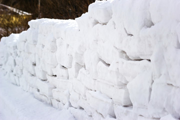 Fototapeta na wymiar The wall is built of snow blocks