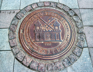 Circular manhole cover in the historical center of Tartu, Estonia