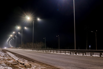 Fast moving traffic at night. Timelapse. winter season. concept of the road, snow and ice removal, danger and safety of movement, street lighting with energy-saving lamps