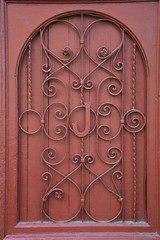  old scarlet wooden door with wrought iron and letter  J
