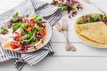 hearty pancakes with fresh salad, tomato and radicchio
