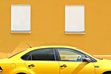 taxi car yellow wall parked car parking parking tinted windows headlights closed sun street city moscow russia private vehicles