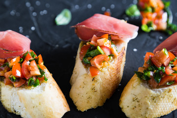 Bruschetta with prosciutto, tomatoes and basil