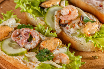 Seafood bruschetta toasted bread topped with fresh salad, parsley, cucumber, creme cheese, shrimp, octopus, mussel. Close up.