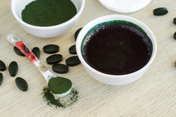 Spirulina facial mask in the small white bowl. Natural beauty treatment. 