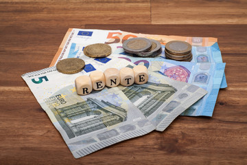 Die Euro Geldscheine und Münzen liegen auf dem Tisch mit dem Wort Rente