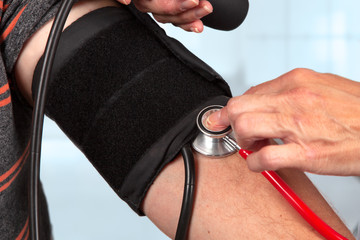 a doctor measures the blood pressure manually with a stethoscope