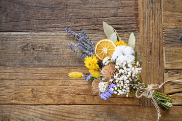 Dried flowers in bouquet on wooden background