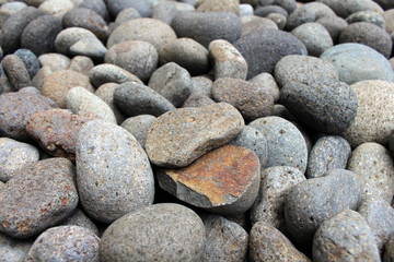 A broken pebble among stones in the garden.