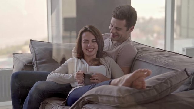 Pleased lovely couple having rest together while sitting on bed