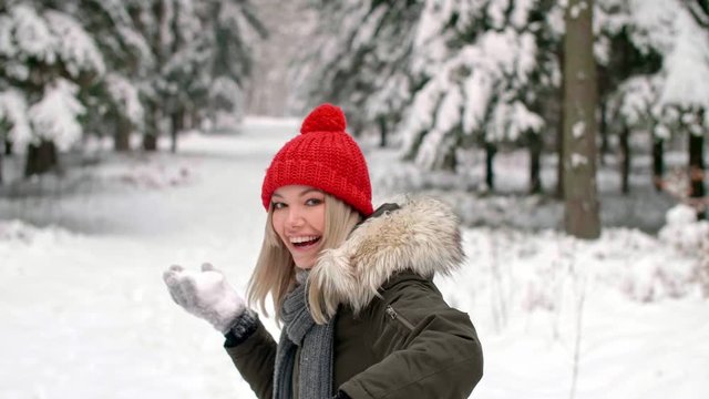 Girl throwing snowball right on the camera