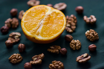 Close up of orange and nuts on dark background