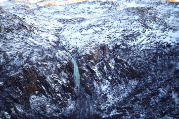 Berglandschaft mit einem gefrorenem Wasserfall beim Sonnenuntergang auf Tromsø, Norwegen