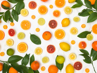 many different fresh citrus fruits on white crumpled paper background