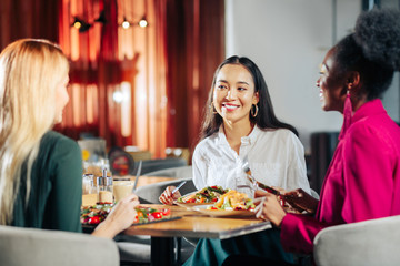 Three friends meeting on restaurant for tasty lunch together