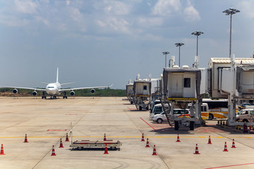 Mandalay International Airport, Mandalay, Myanmar. Airplane on runway beside row of tunnels - footbridges, Burma.