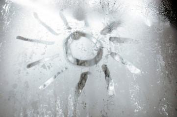 Figure of the sun on the ice glass. Cold in winter