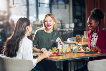 Blonde-haired woman with nice makeup speaking with her friends