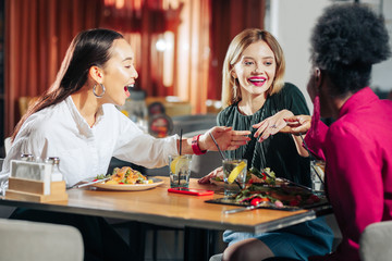 Friends feeling excited while looking at engagement ring of their friend