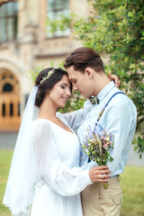 Naklejka premium The first walk of the newlyweds, walking hug, love each other. girl in her hands holding flowers