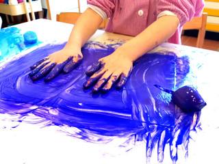 closeup of children hands painting during a school activity - ice painting -  learning by doing, education and art, art therapy concept