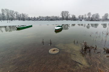 Naklejka premium Beautiful frozen river. A boats covered with snow.