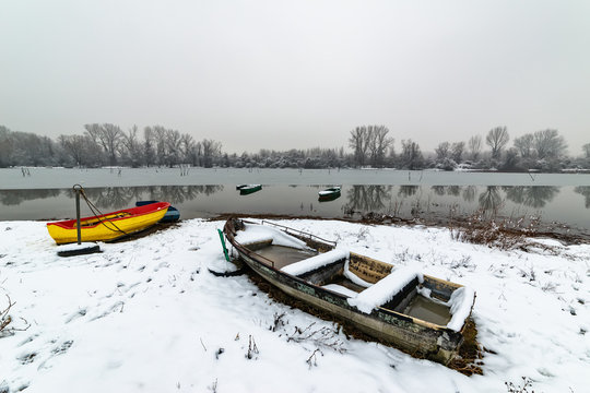 Beautiful frozen river. A boats covered with snow.