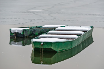Naklejka premium Beautiful frozen river. A boats covered with snow.